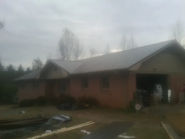 Gray metal roof on a stucco house with an attached garage in Point Marion