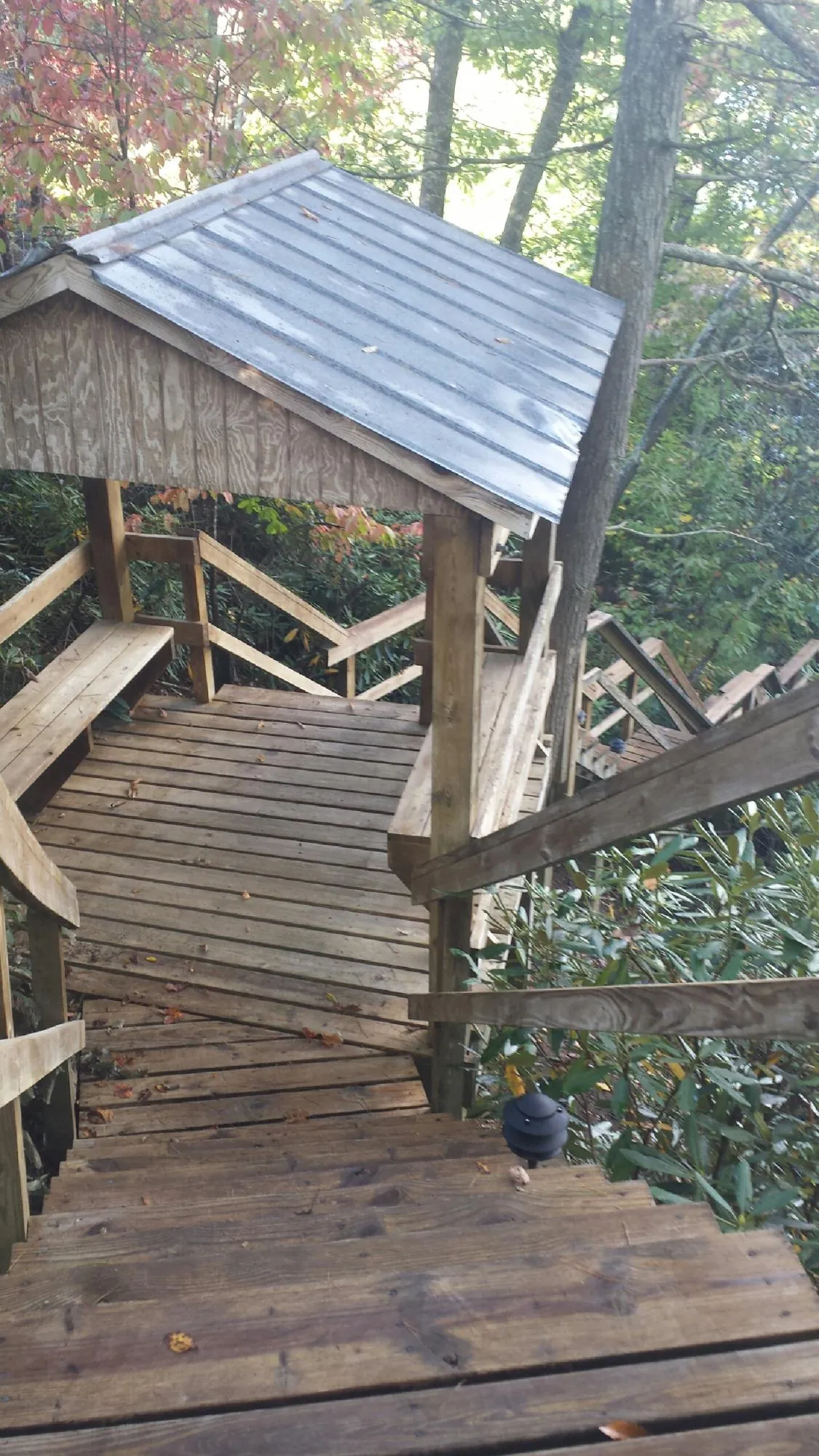Metal roofed shelter over wooden steps on a wooded walkway — Skylight Repair & Installation work by our crew in Point Marion