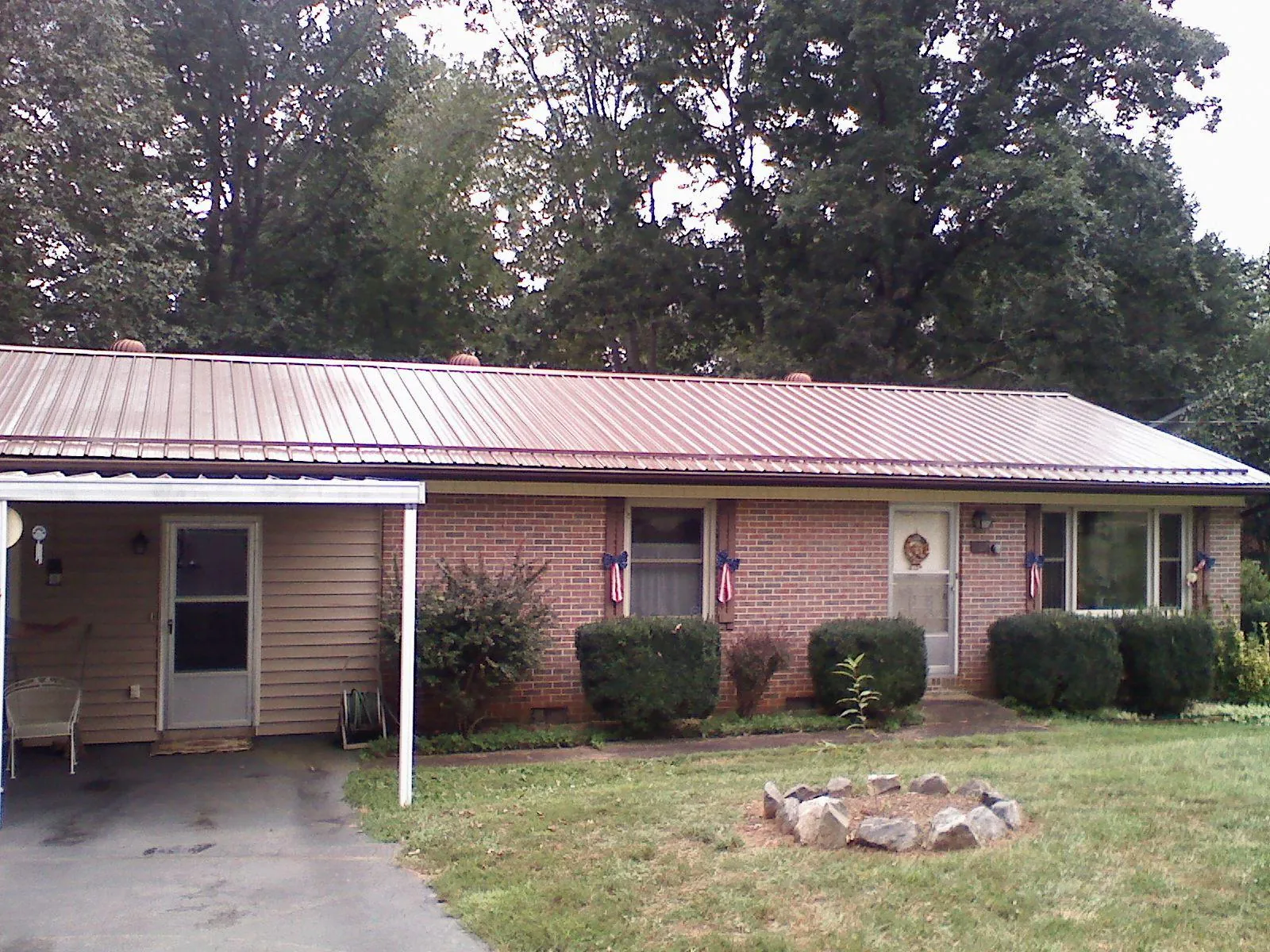 Bronze metal roof and carport on a brick ranch home — Roof Repair work by our crew in Point Marion