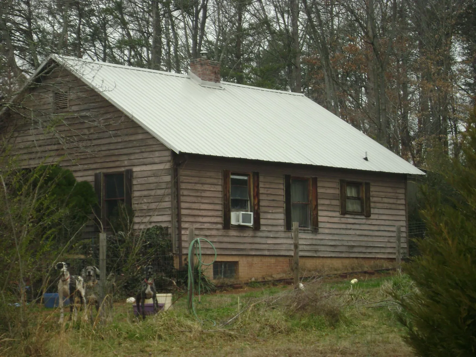 White metal roof on an old wood sided farmhouse, from a Metal Roof Installation job in Point Marion